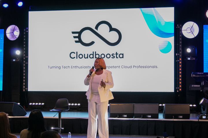Gbemisola Ojo speaking on stage in front of the Cloudboosta screen