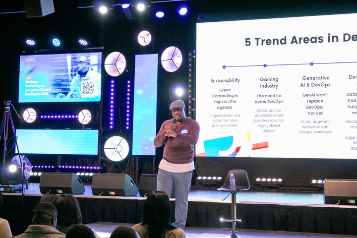 Speaker presenting a slide titled 5 Trend Areas in DevOps